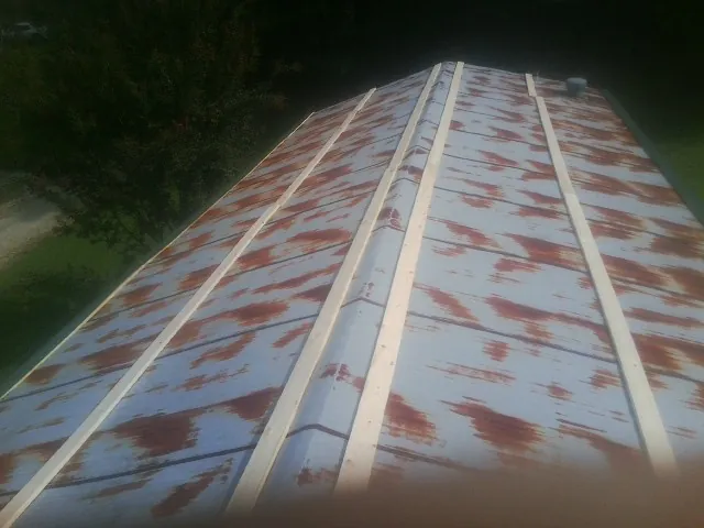 Rusted metal roof panels with new wood purlins before replacement — Storm Damage Roof Repair in Nada by Roofing Brothers