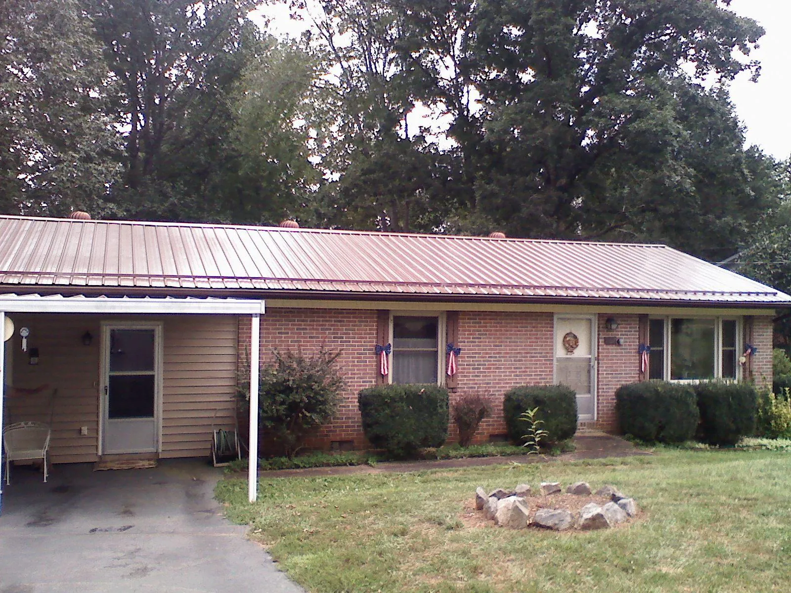 Bronze metal roof and carport on a brick ranch home — Roof Repair work by our crew in Nada